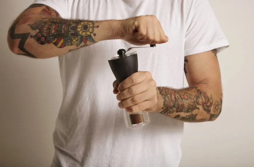 Man grinding coffee beans with a manual coffee grinder