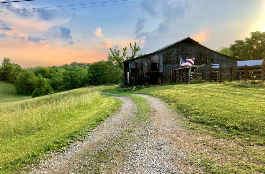 Old barn at the end of a gravel farm road, a typical start for homesteading in Tennessee