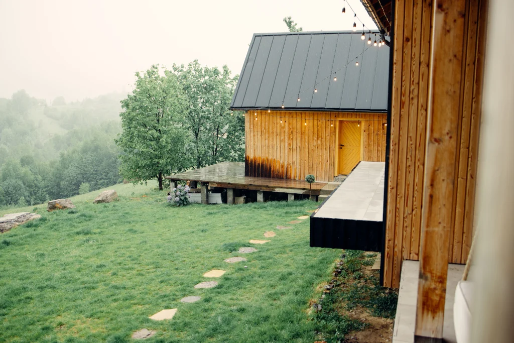 wooden-cabin-in-the-rain-with-green-grass-and-stone-path