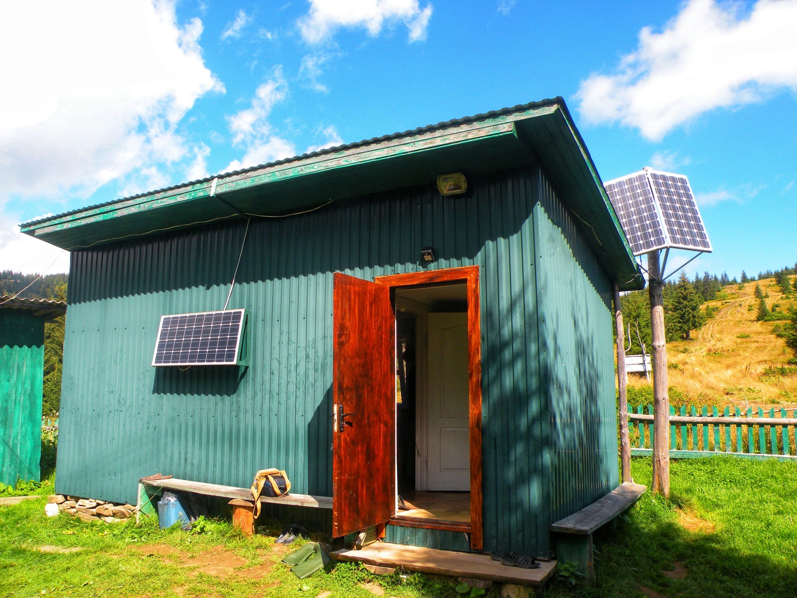 Old wooden shed with solar panels.
