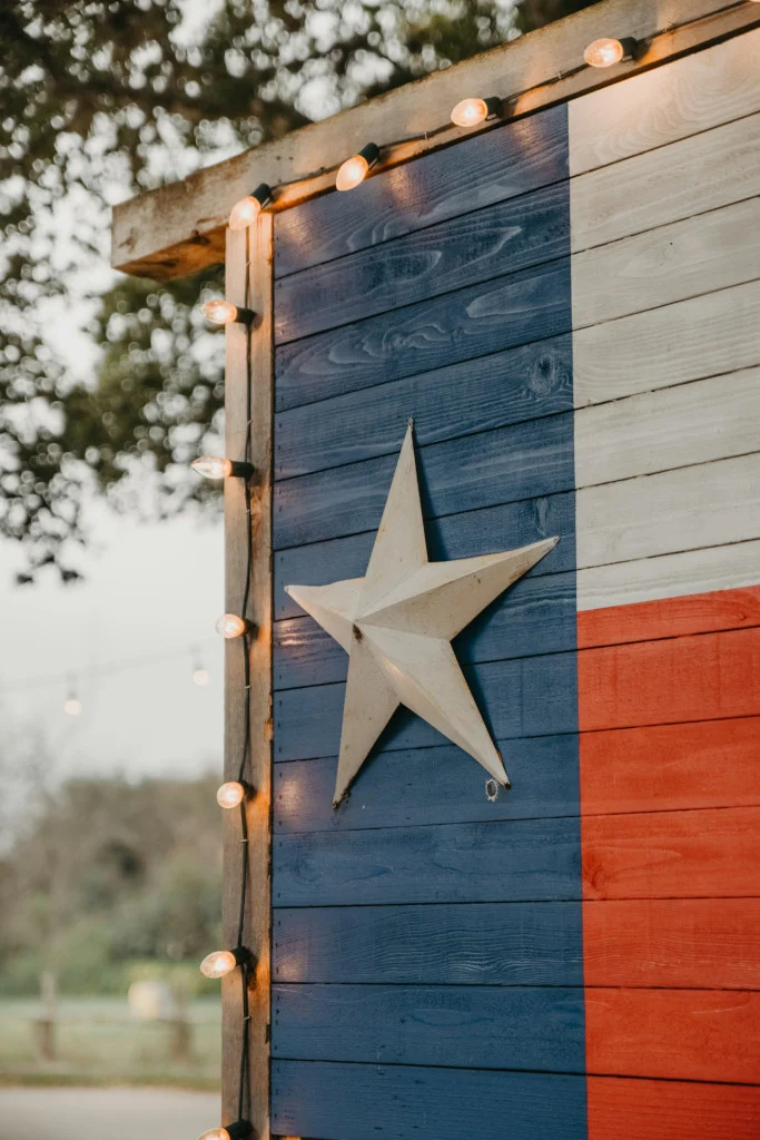 Texas flag painted on a weathered wooden barn wall