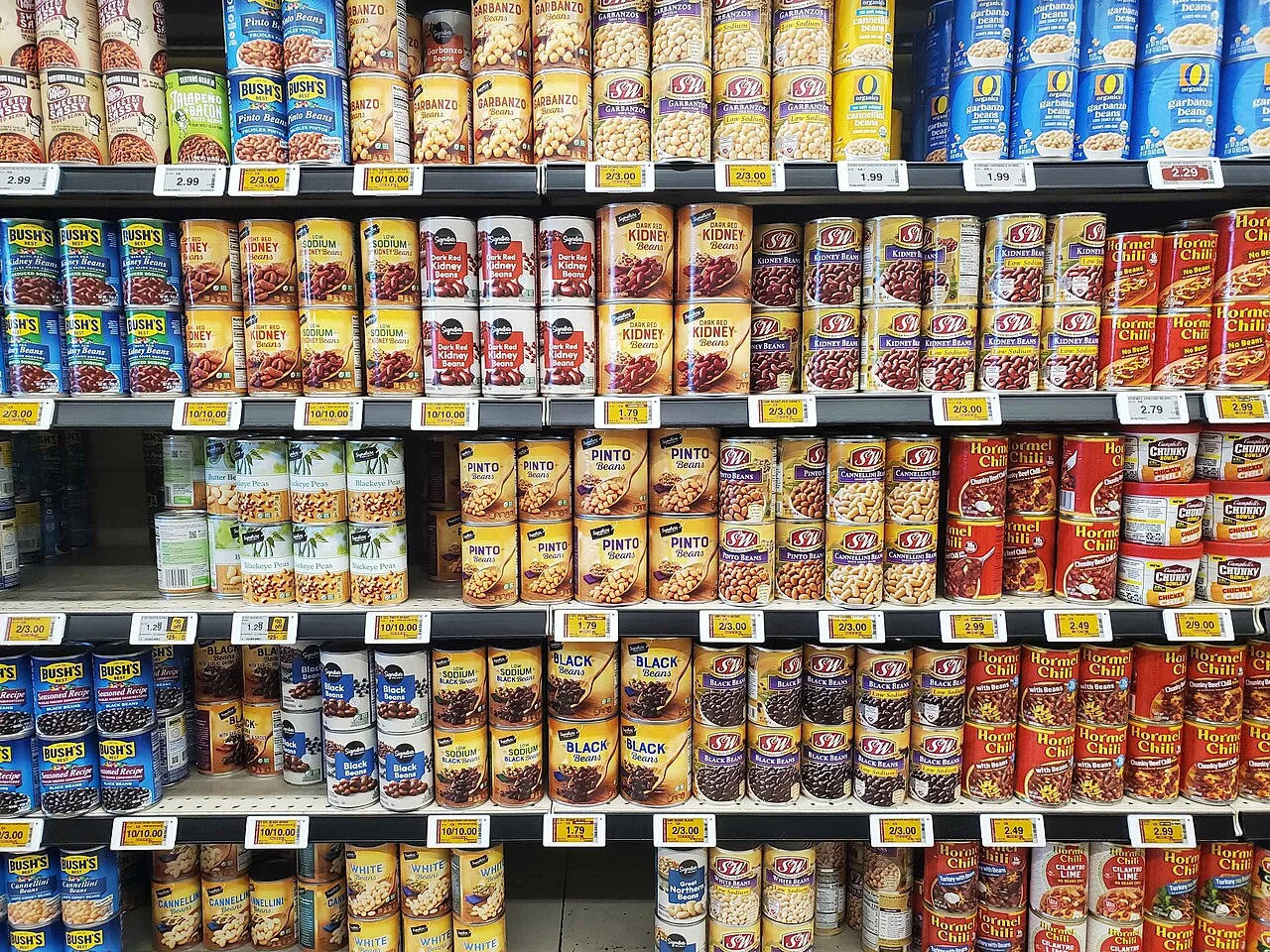 Canned beans and chili on a supermarket shelf for an emergency pantry