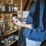 Emergency pantry: wooden shelves with glass jars of grains, beans and spices