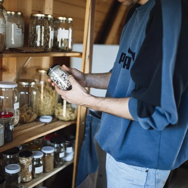 Emergency pantry: wooden shelves with glass jars of grains, beans and spices