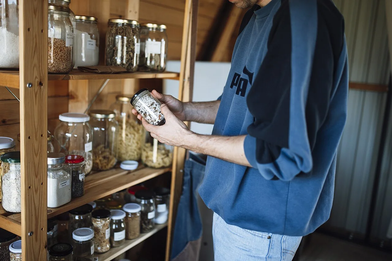 Emergency pantry: wooden shelves with glass jars of grains, beans and spices